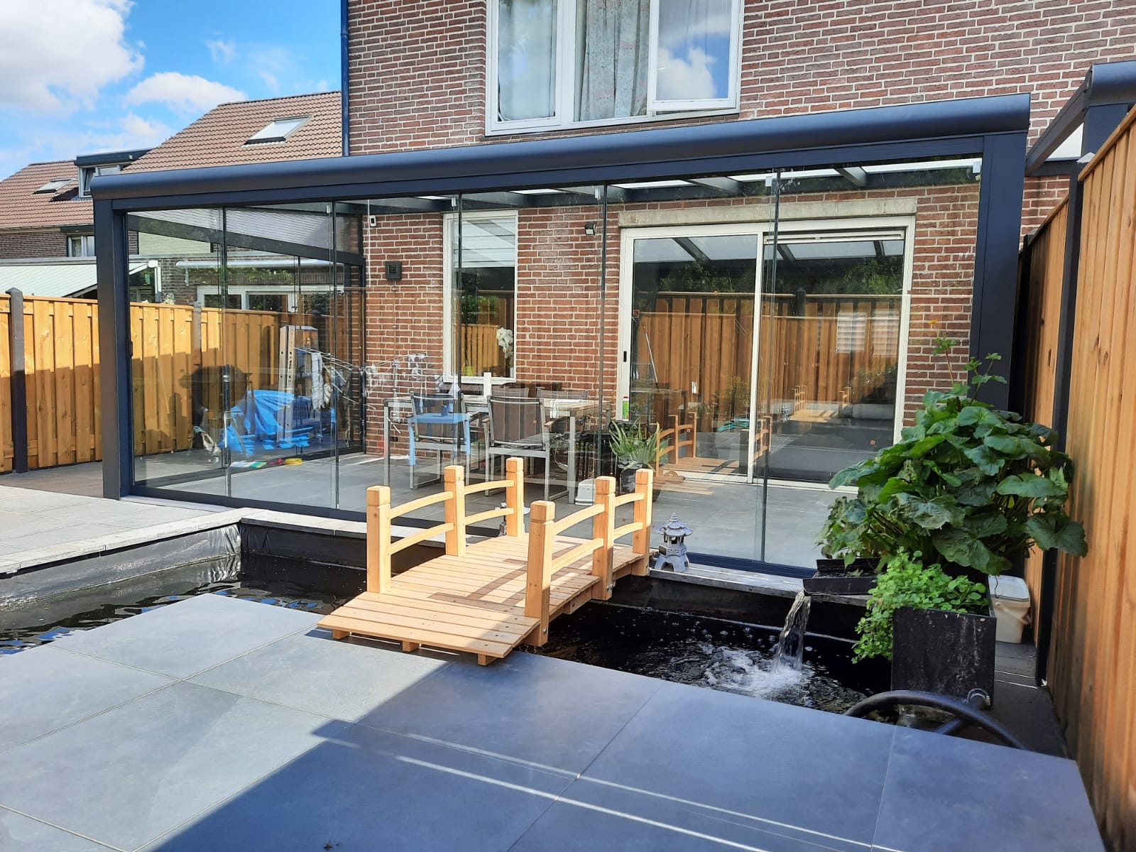 Aluminium veranda met glazen schuifwanden aan een woning